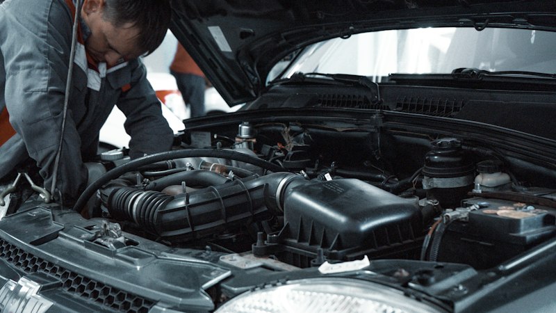 Mechanic inspecting vehicle engine